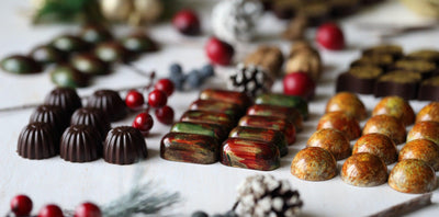 Viele kleine bunte Pralinen die perfekt angeordnet sind mit weihnachtlicher Dekoration