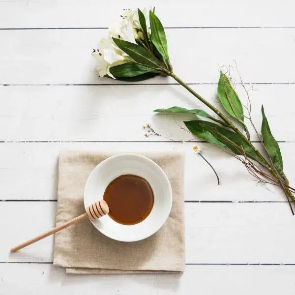 Manuka Honig im Schale angerichtet mit Blumen als Dekoration