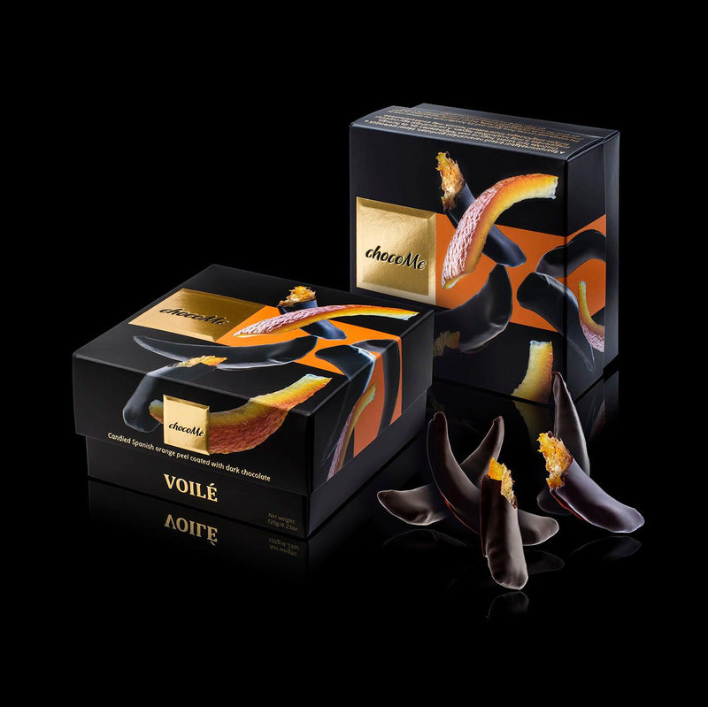 Kandierte Orangenschale mit dunkler Schokolade von ChocoMe mit zwei Boxen als Deko schwarzer Hintergrund