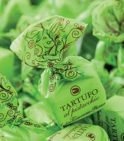 Mehrere grüne Tartufi Dolci Pralinen mit Pistazien von Antica Torroneria Piemontese füllen das Bild aus